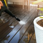 cleaning wooden terrace planks with high pressure washer