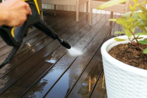 cleaning wooden terrace planks with high pressure washer